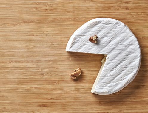 A bird's-eye photograph of a wheel of brie on a wooden table